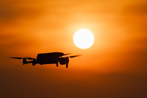 Drone,Silhouette,Flying,In,Front,Of,Bright,Sun,At,Sunset.